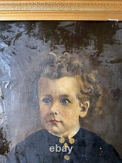 Grand tableau à l'huile ancien d'un enfant dans un cadre en bois sculpté orné de dorure.